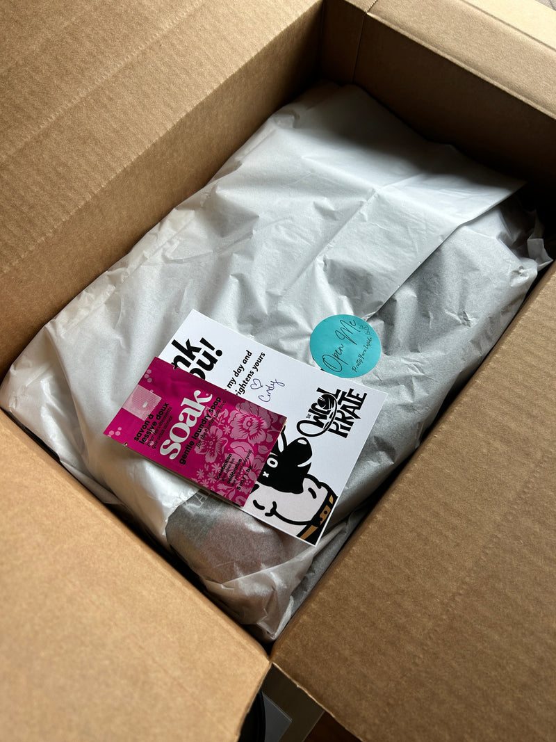 Photo of yarn wrapped in tissue, sticker and thank you card