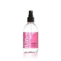 Clear spray bottle with pink label on a white background