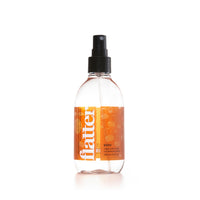 Clear spray bottle with orange label on a white background
