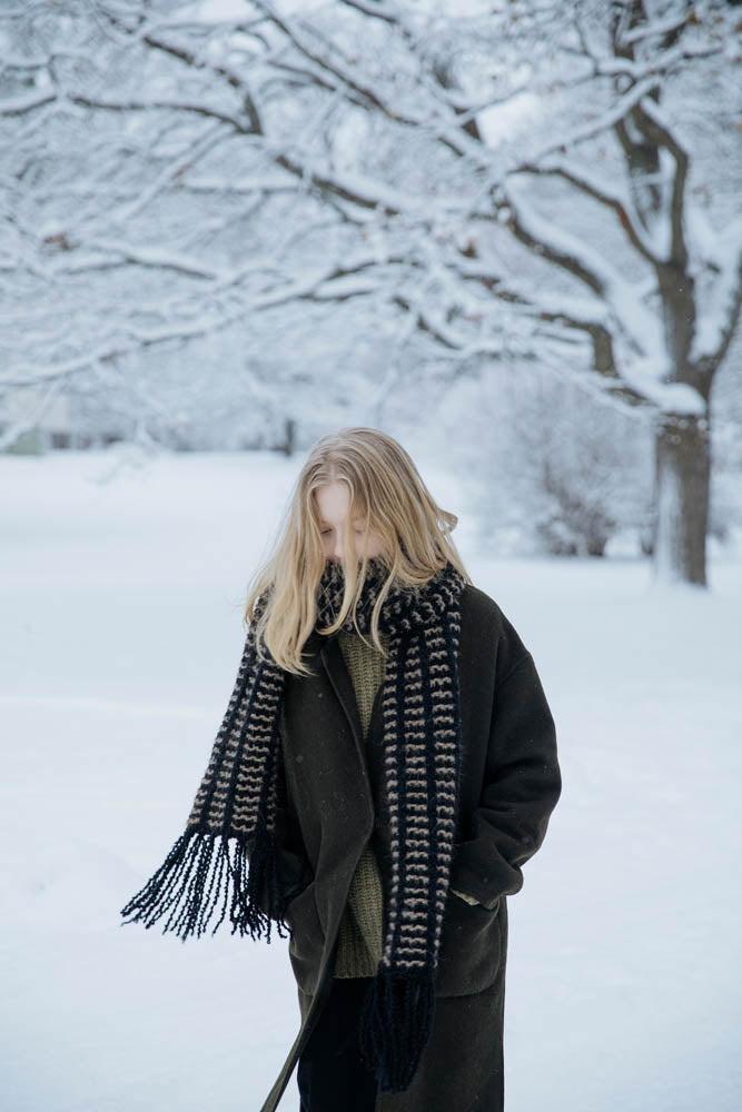 image of a knit scarf being worn on a woman in a snow scene