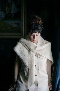 shawl wrapped around a person who is standing in front of a window