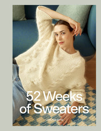 A woman wearing a chunky cream cable-knit sweater sits on a patterned rug in a living room setting, with large white text overlay reading '52 Weeks of Sweaters' 