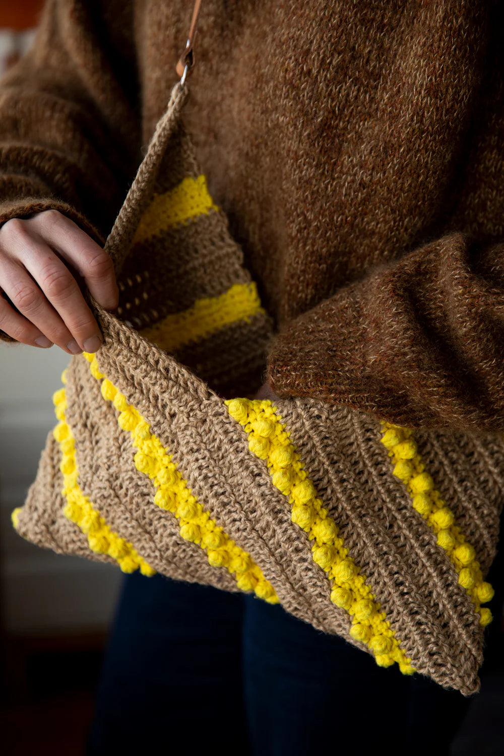image of a knit purse on a person with only hands being seen