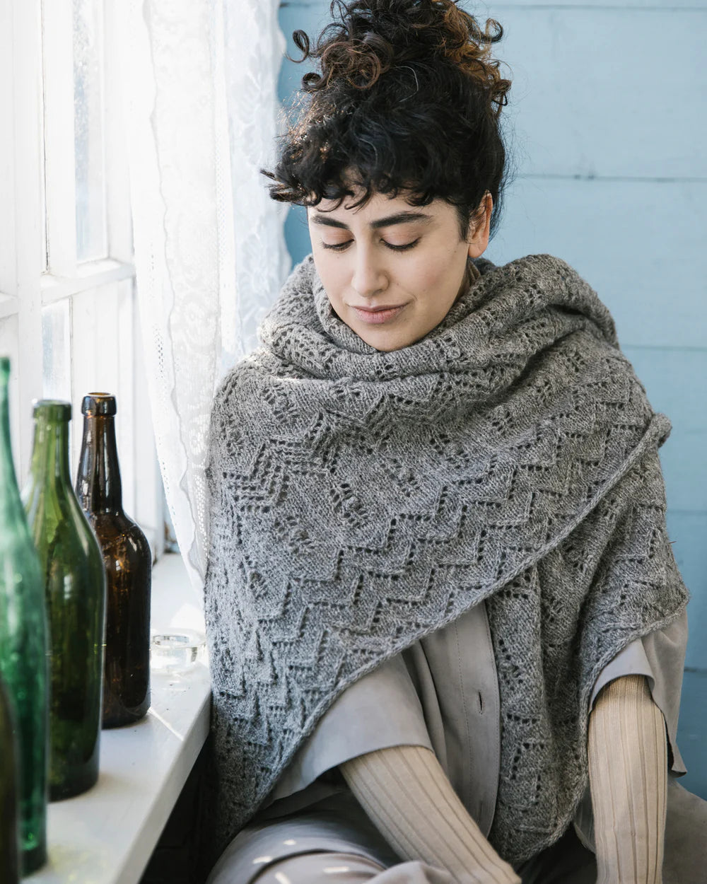 a shawl wrapped around a person sitting in front of a window