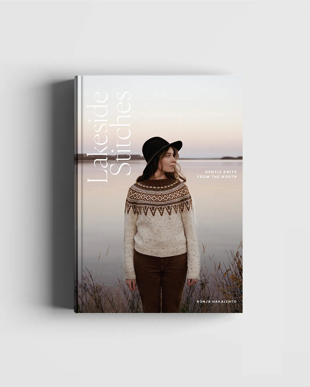Book titled 'Lakeside Stitches' with a person wearing a patterned sweater and hat on the cover.