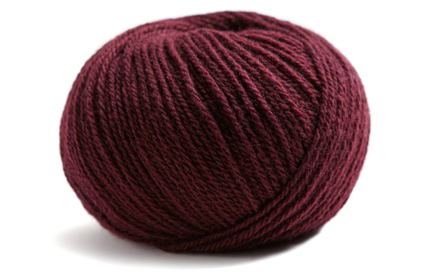 deep red ball of yarn on a white background