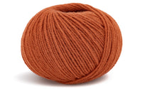 burnt orange colour ball of yarn on a white background