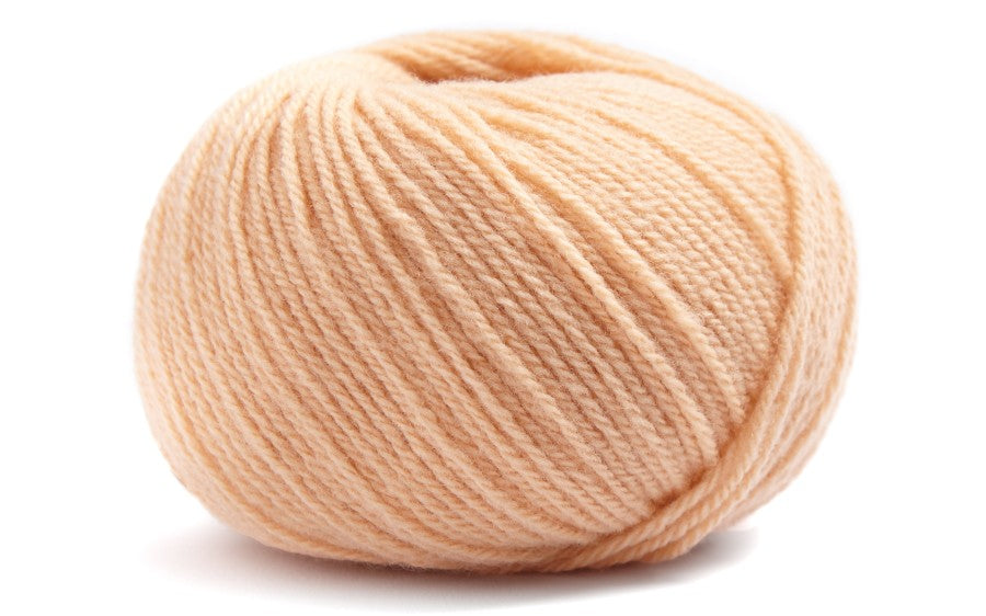 light peach coloured ball of yarn on a white background