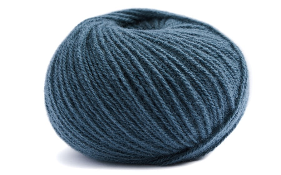 medium blue coloured ball of yarn on a white background