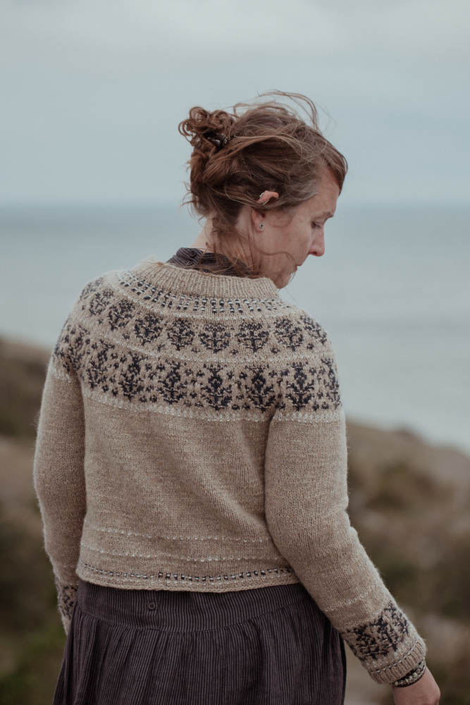 Woman wearing a patterned sweater by the sea