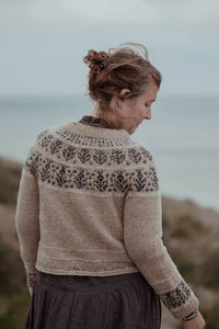 Woman wearing a patterned sweater by the sea