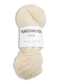 Ball of undyed / white natural yarn against a white background