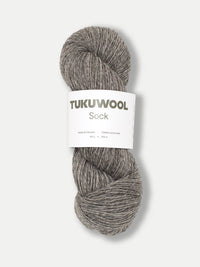 skein of grey tweed like yarn against a white background