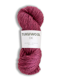 A skein of Tukuwool DK yarn in a dusty rose or mauve pink color, wrapped with a white paper label, on a white background.