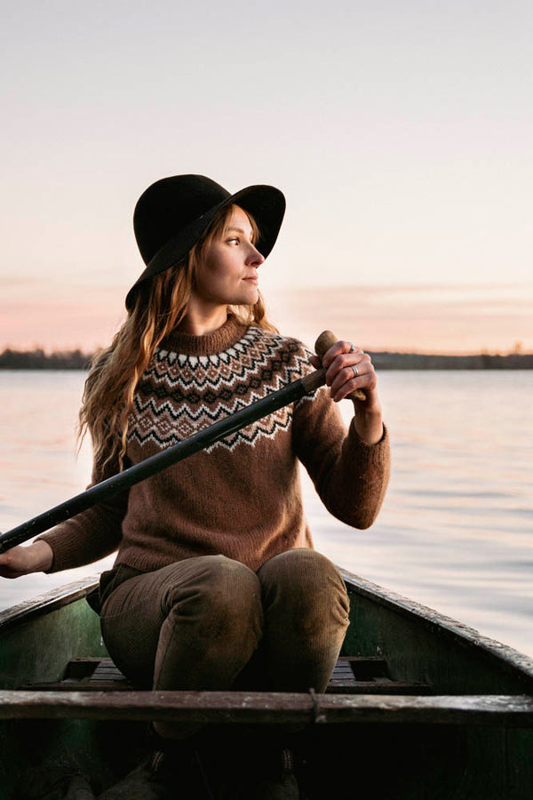 Image of sweater pattern being worn on woman in a canoe