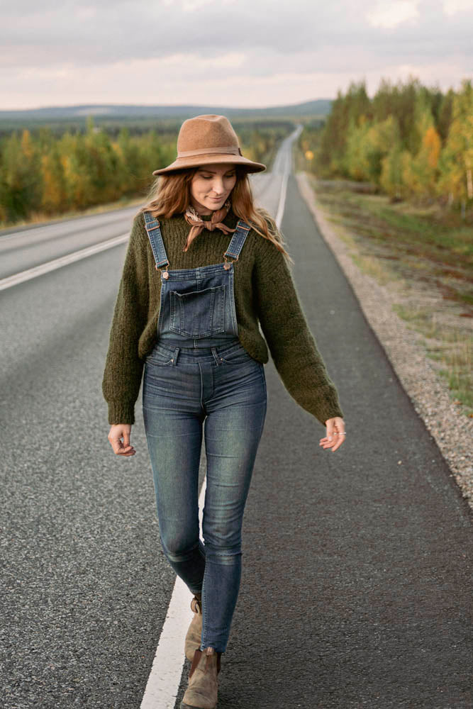image of sweater pattern being worn on a woman walking on a paved road in the wilderness