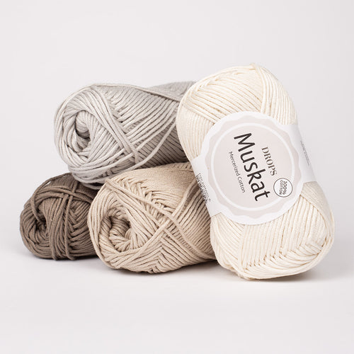Three skeins of yarn in beige, brown, and gray with a 'Muskat' label on a light gray background.